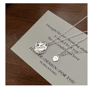 Détail du collier pendentif lave en argent s925 avec texture sur carte minimaliste