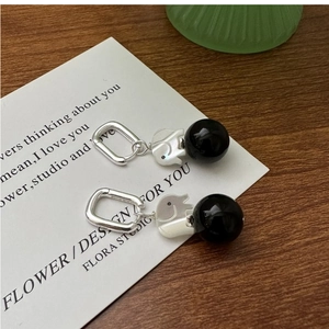 Macro shot of silver elephant earrings with polished black onyx beads on white card