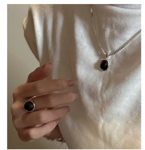 Detail of S925 sterling silver ring and necklace set featuring oval black onyx gemstones