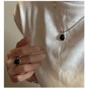 Détail du parure collier et bague en argent S925 avec agate noire sur tricot blanc