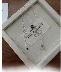 Detail of S925 sterling silver Saturn pendant with brown bead on a Figaro chain link