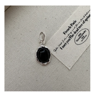 Détail macro du pendentif en onyx noir ovale avec cadre argenté irrégulier