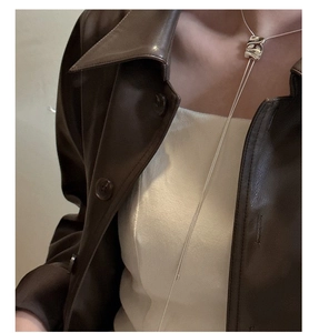 Detail of s925 silver square slide pendant necklace on leather jacket outfit