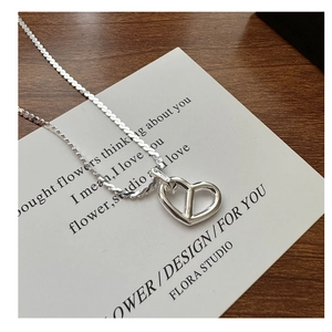 Close-up of S925 sterling silver hollow heart pendant on a fine snake chain necklace