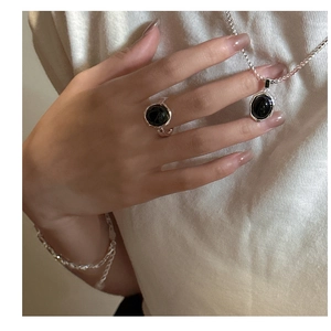 Close-up of S925 sterling silver jewelry set with black agate and hammered texture