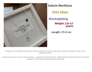 Macro shot of S925 sterling silver Saturn pendant with dark stone on an elegant chain
