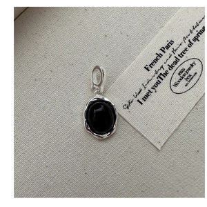Détail macro du pendentif onyx noir ovale avec bordure argentée à texture de lave