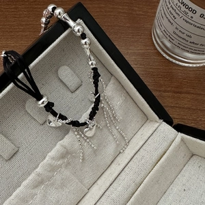 S925 silver heart tassel bracelet with black woven cord and beads in a jewelry box