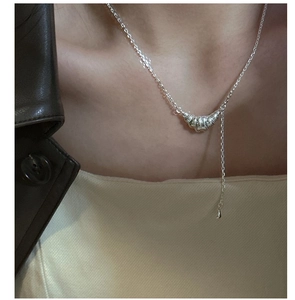 Détail du collier pendentif croissant en argent sur la clavicule avec chaîne pendante
