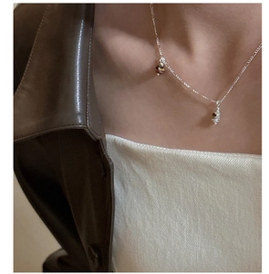 Detail of S925 silver Figaro chain necklace featuring tiger eye and stone beads on a model