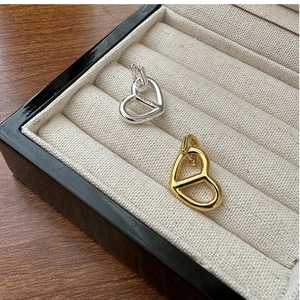 Detail of S925 sterling silver heart pendants in gold and silver finish with hallmark