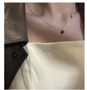Close-up of S925 sterling silver Saturn necklace with tiger eye bead and metal ball pendant