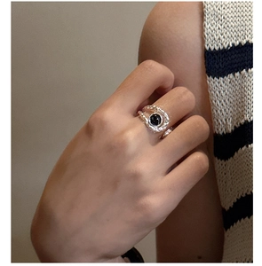 Detail of vintage textured silver ring with black agate stone worn on model's hand