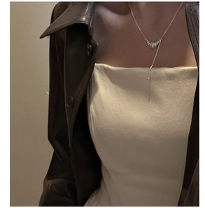 Détail du collier croissant en argent S925 sur mannequin avec un look mode superposé