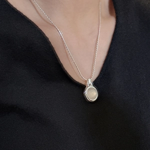 Minimalist S925 silver necklace with a round white agate pendant on a black V-neck top