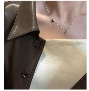 Close-up of S925 sterling silver Saturn necklace on model with two-tone pendants
