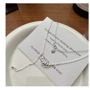 Détail macro du collier croissant en argent S925 sur une élégante carte de décor