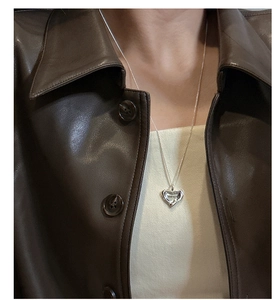 Detailed macro view of S925 sterling silver heart pendant with engraved script on o-chain