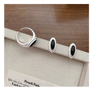 Detail of brushed silver jewelry set featuring oval black onyx stone ring and earrings