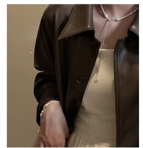 Detailed view of shimmering S925 sterling silver tassel necklace and bracelet set on a model
