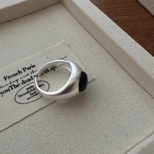 Minimalist S925 sterling silver matte ring with oval black onyx stone on jewelry tray