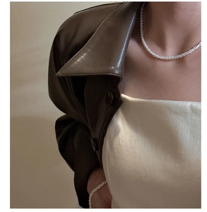 Close-up of sparkling S925 sterling silver tennis necklace on model with leather jacket