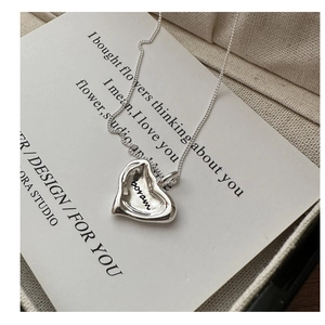 Detailed shot of an irregular S925 silver heart pendant necklace on a gift card