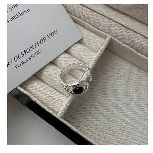 Detail of vintage S925 silver ring with hammered texture and round black agate stone