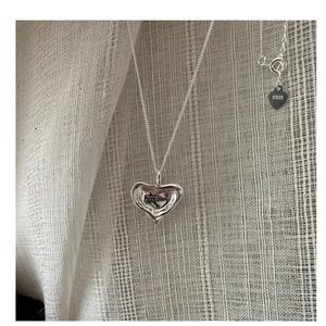Macro shot of S925 sterling silver heart necklace with boram engraving and lava texture