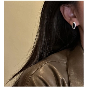 Detail shot of vintage oval black agate earrings on a model in minimalist style