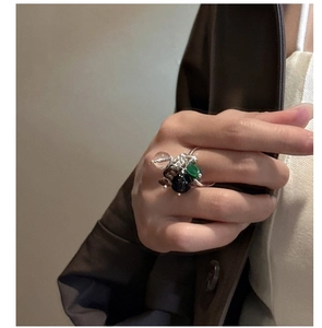 Detail of S925 sterling silver beaded ring with green crystal charms on a model hand