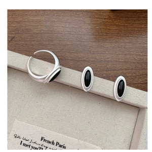 Detail of vintage matte silver jewelry set with oval black onyx ring and earrings