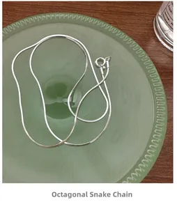 Detailed close-up of S925 sterling silver square snake chain necklace on a glass tray