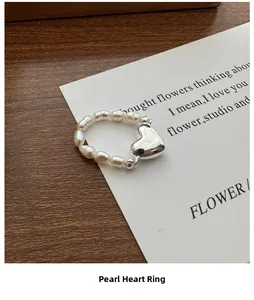 Détail d'un pendentif cœur en argent S925 sur une bague de perles d'eau douce