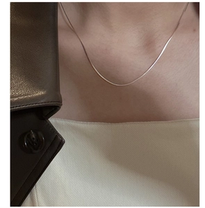 Close-up of minimalist 925 sterling silver snake bone chain necklace on a model
