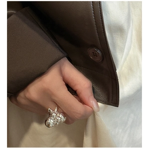 Close-up of a silver spherical cluster ring featuring artistic irregular metal balls on a hand