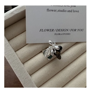 Macro detail of S925 silver beaded ring with mixed stone charms in a jewelry box