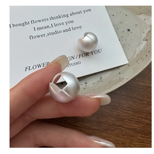 Dettaglio macro degli orecchini a sfera in argento S925 con finitura satinata e opaca chic