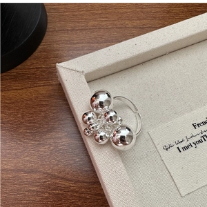 Macro view of polished S925 silver ring featuring modern minimalist bead droplet design