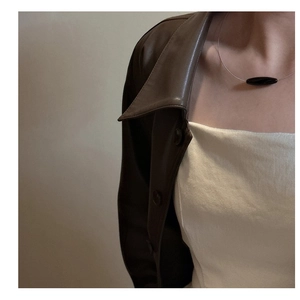 Detail of minimalist S925 silver necklace with black agate pendant on model neck
