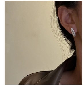 Close-up of S925 sterling silver spiral stud earrings with sparkling zircon stones