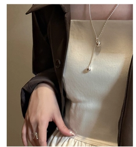 Detail of silver S925 lariat necklace with double sphere pendant and geometric ring