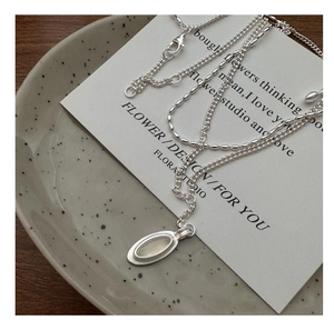 Detail of silver S925 double layer necklace featuring an oval opal gemstone pendant