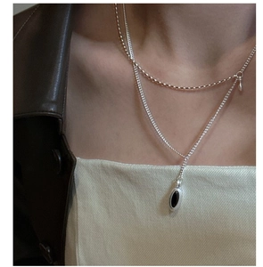 Detail of S925 sterling silver double layer teardrop necklace on model with leather jacket