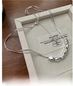 Close-up of S925 sterling silver snake chain necklace with irregular textured square charms