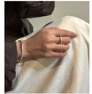 Detail of S925 silver braided cuff bracelet and ring set with gold accent on a model