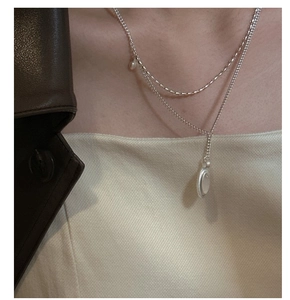 Detail of S925 sterling silver double layer necklace with pearl and oval pendant