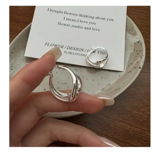 Close-up of S925 sterling silver hollow double hoop earrings with a polished twisted design