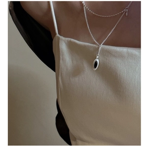 Detail of silver S925 double-layer necklace with a black oval pendant on model