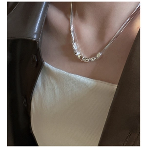 Detail of S925 silver necklace with textured irregular beads on a female model
